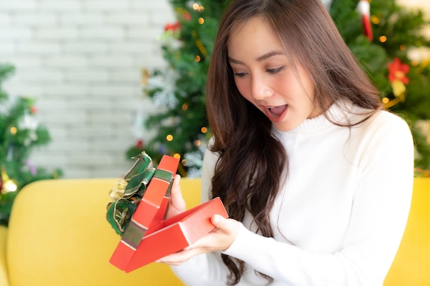 Hermosa chica abrir caja de regalo de regalo de navidad