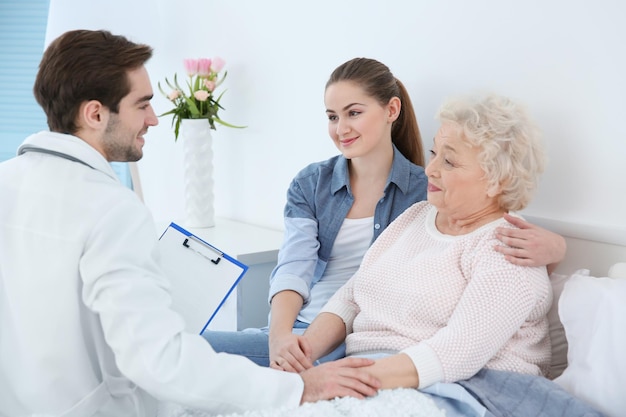 Hermosa chica con abuela visitando al médico