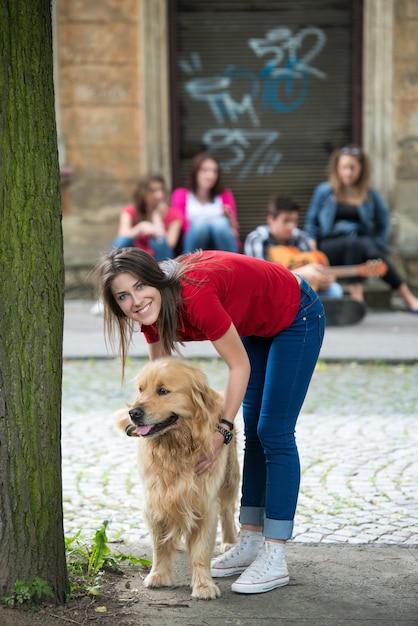 Hermosa chica acariciando a un perro