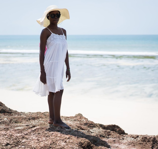 Hermosa chica afroamericana en la arena de la playa de mar