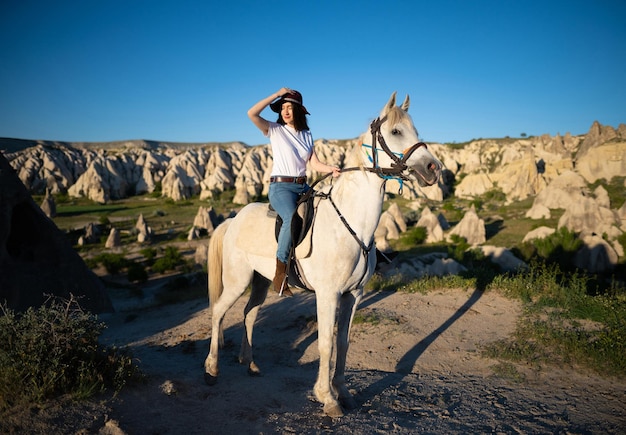 Hermosa chica al aire libre en las montañas con su fiel caballo