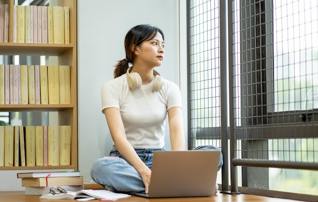 Hermosa chica asiática estudiando en la biblioteca