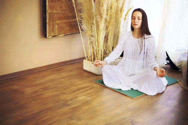 Hermosa chica atlética haciendo ejercicios de yoga disfruta de la meditación en casa Sin estrés