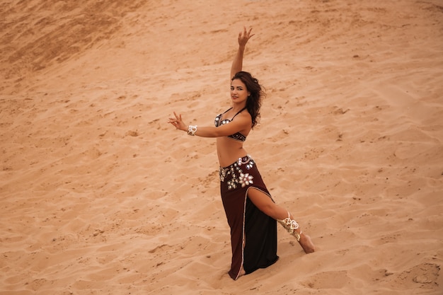 Hermosa chica bailando danzas étnicas en el desierto. Hermosa bailarina del vientre