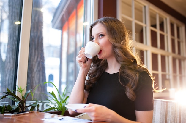 Hermosa chica bebe café