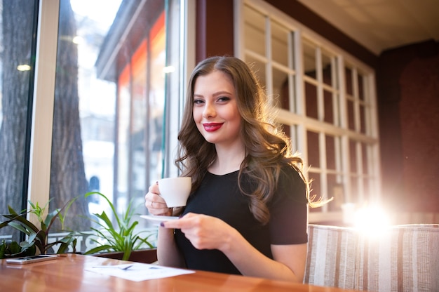 Hermosa chica bebe café