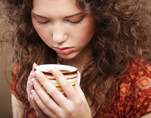 Hermosa chica bebiendo té o café.