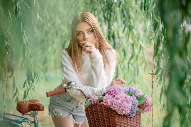 Hermosa chica en bicicleta con flores.