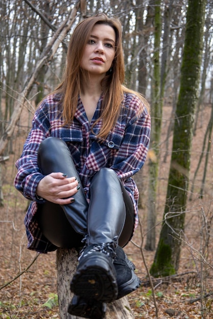 Hermosa chica en el bosque cerca de los árboles