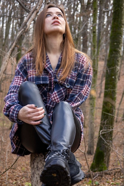 Hermosa chica en el bosque cerca de los árboles