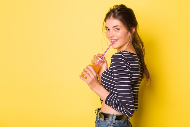 Hermosa chica con una botella de jugo fresco