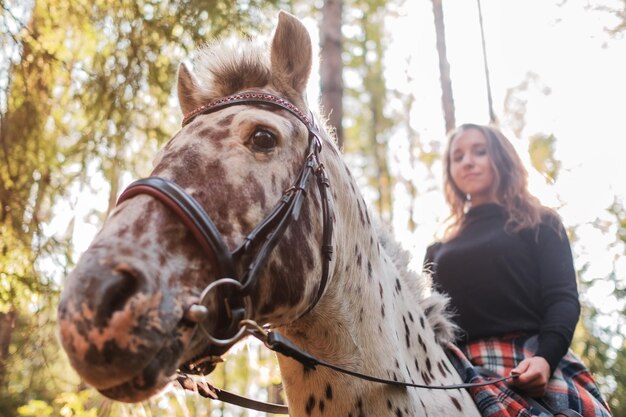 Hermosa chica a caballo en el campo