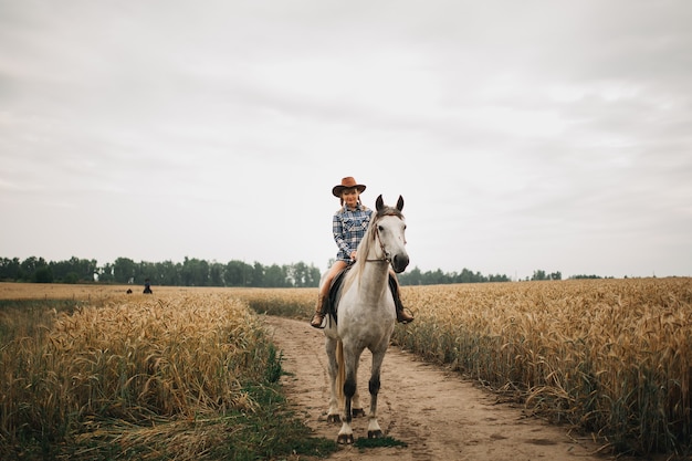 Hermosa chica a caballo en el campo