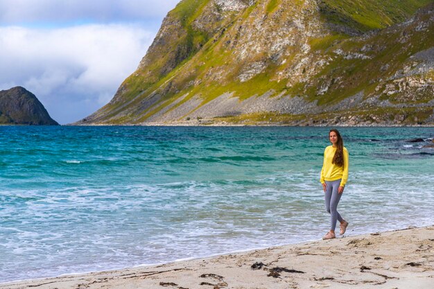 una hermosa chica de cabello largo disfruta del clima soleado en la famosa playa paraíso haukland, noruega