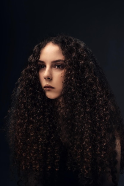 Foto hermosa chica de cabello rizado posando para la cámara