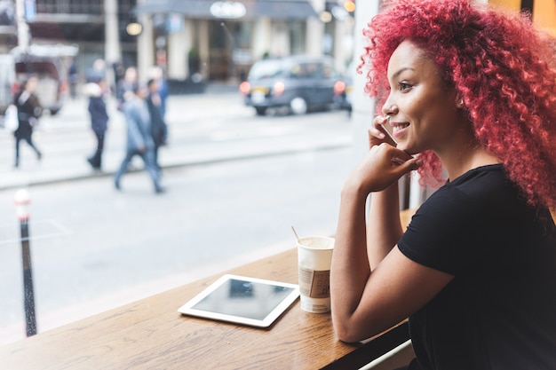 Hermosa chica en un café hablando por teléfono inteligente