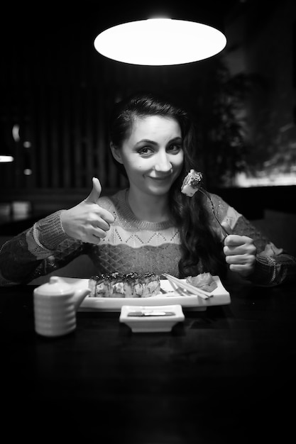 Hermosa chica en un café tomando una taza de café en una cena