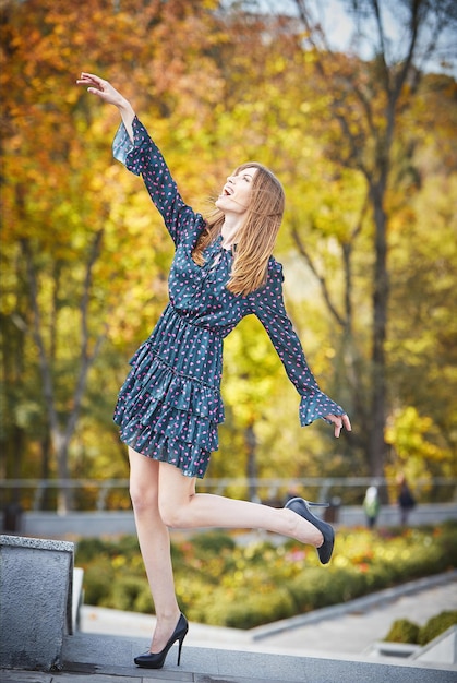 Hermosa chica caminando en el parque en otoño