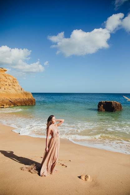 Hermosa chica caminando por la playa al atardecer, concepto de libertad