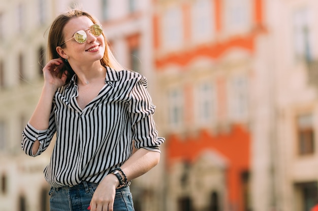 Hermosa chica en una camisa a rayas con cabello largo