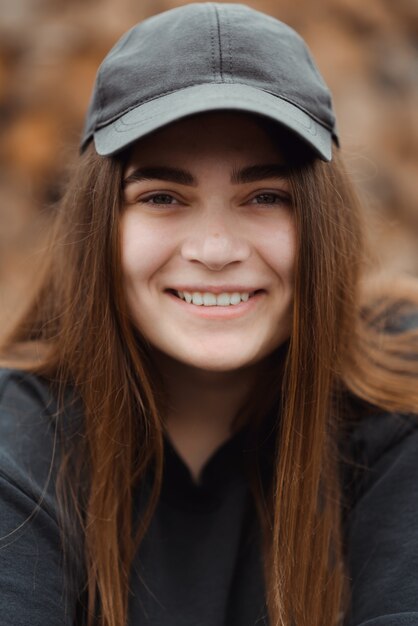 Hermosa chica con camiseta casual sobre fondo marrón mirando a la cámara con una sonrisa en la cara, expresión natural.