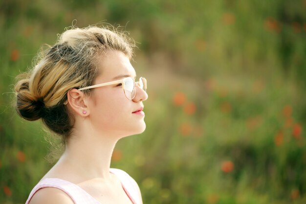 Hermosa chica en el campo de amapolas.