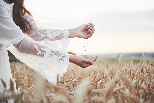 Hermosa chica en un campo de trigo con un vestido blanco, una imagen perfecta en el estilo de vida.