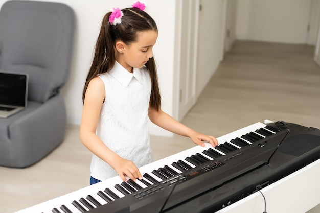 hermosa chica canta mientras toca un piano electrónico.