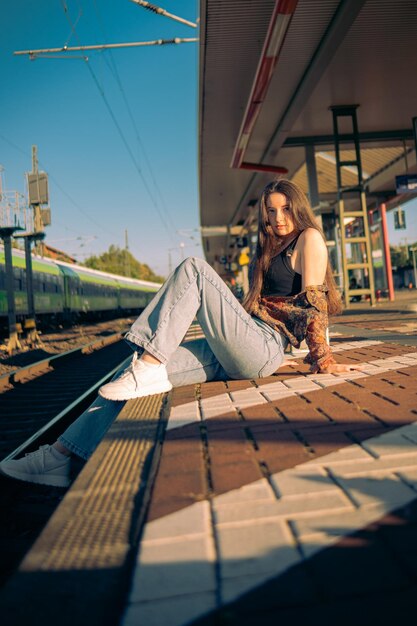 Hermosa chica caucásica posando en el andén del ferrocarril