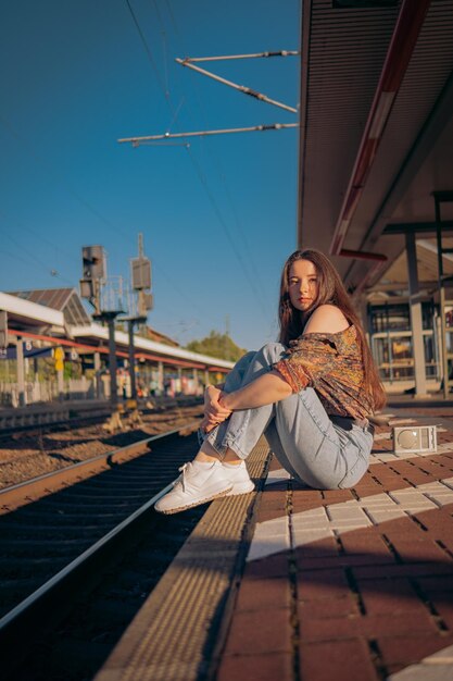 Hermosa chica caucásica posando en el andén del ferrocarril