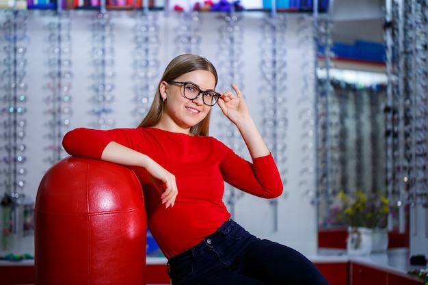 Hermosa chica en un centro de oftalmología recoge gafas para corregir la visión