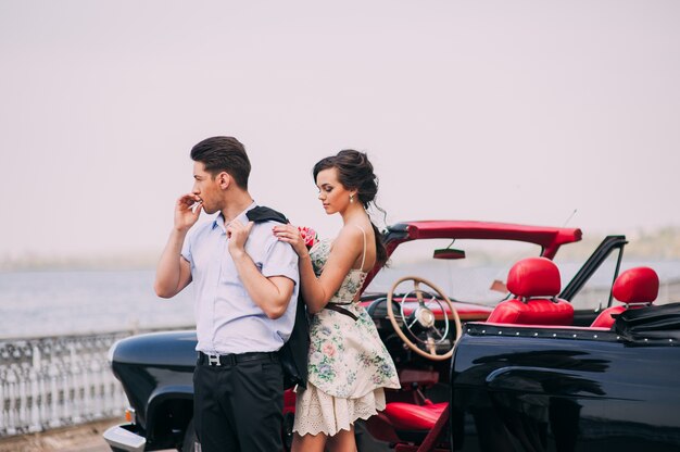 hermosa chica con un chico en un coche retro