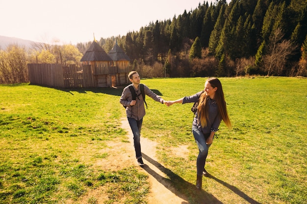 Hermosa chica cogidos de la mano con su novio y guiándolo