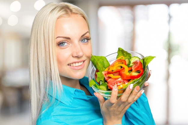 Hermosa chica comiendo una ensalada