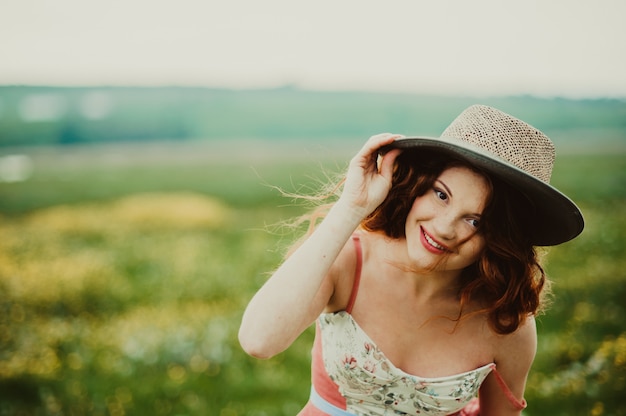 Hermosa chica con un conejo al aire libre en día de verano