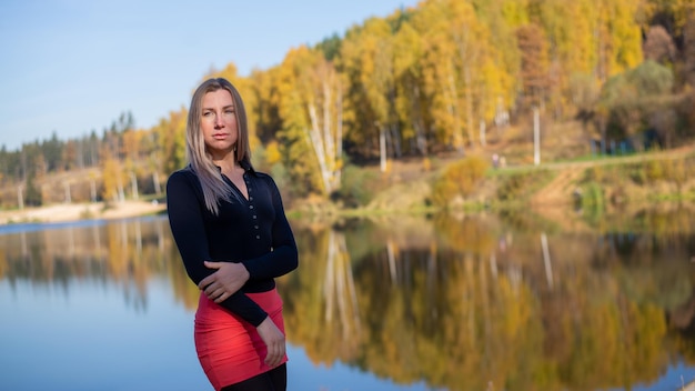 Hermosa chica en el contexto del bosque de otoño y un hermoso lago