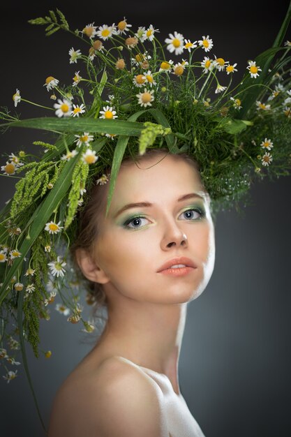 Hermosa chica con una corona de flores silvestres