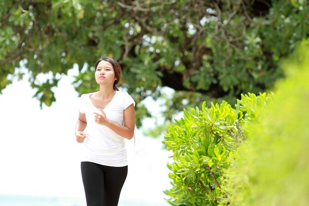 Hermosa chica corriendo en la playa