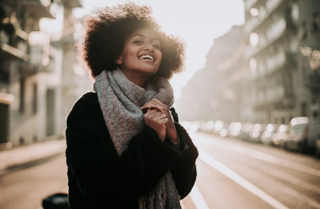 Hermosa chica con corte de pelo afro caminando por la calle