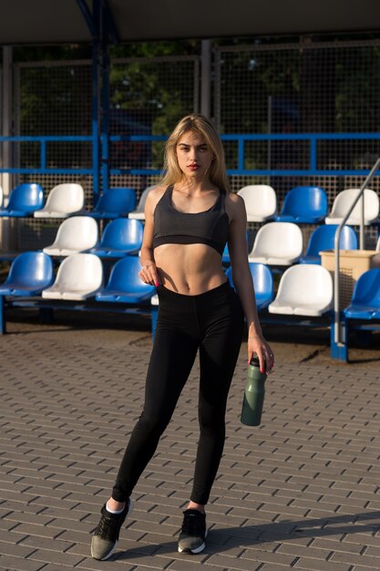 Hermosa chica con un cuerpo deportivo posando en el estadio