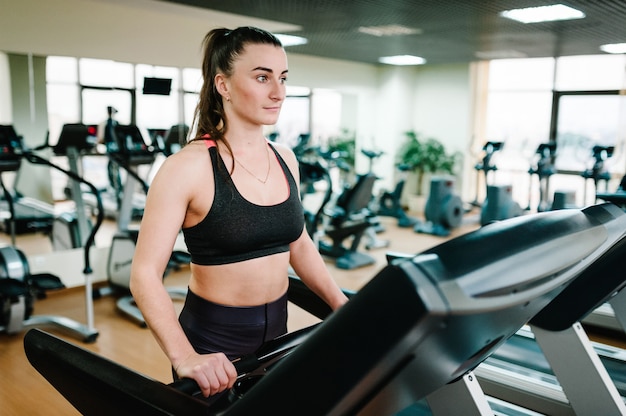 Hermosa chica se dedica a fitness en club deportivo.