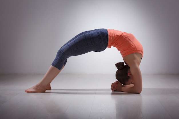 Hermosa chica deportiva yogui en forma practica yoga asana viparita dan