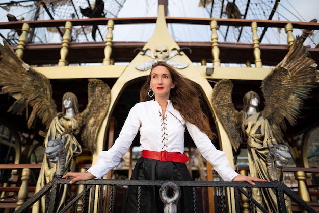 Una hermosa chica con un disfraz de pirata en la cubierta de un barco