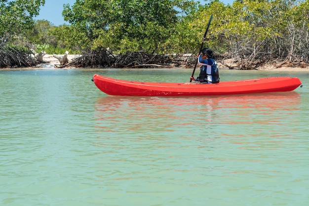 Hermosa chica disfruta con el kayak en el mar en el horario de verano con el concepto de vacaciones en la temporada de verano.