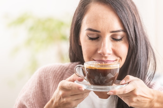 Hermosa chica disfruta del olor a café recién hecho.