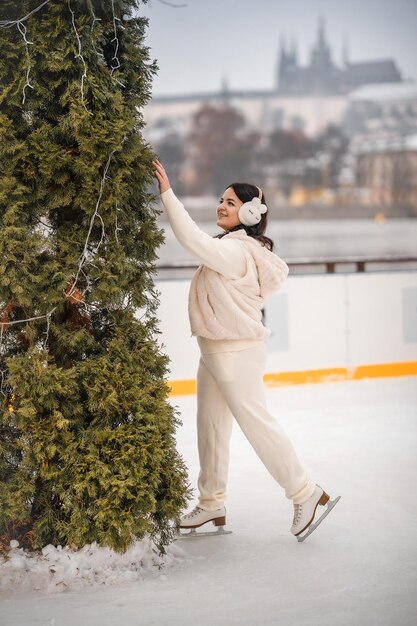 Hermosa chica divirtiéndose mientras patina en la pista de hielo en el fondo del castillo de Praga República Checa