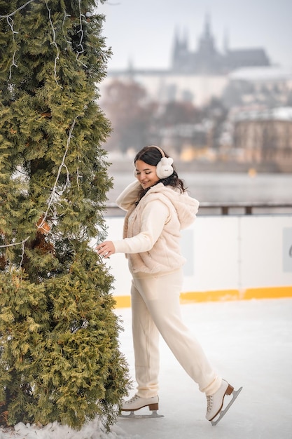 Hermosa chica divirtiéndose mientras patina en la pista de hielo en el fondo del castillo de Praga República Checa