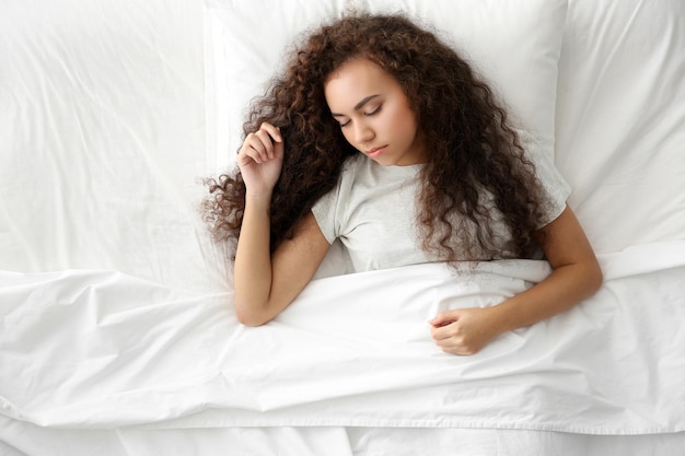 Hermosa chica durmiendo en la cama