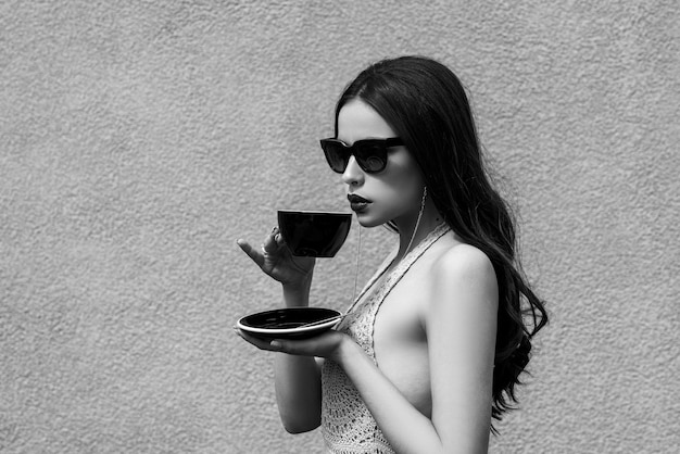 Hermosa chica con elegantes gafas de sol y lápiz labial de bayas oscuras tomando un descanso Vida de lujo de cele