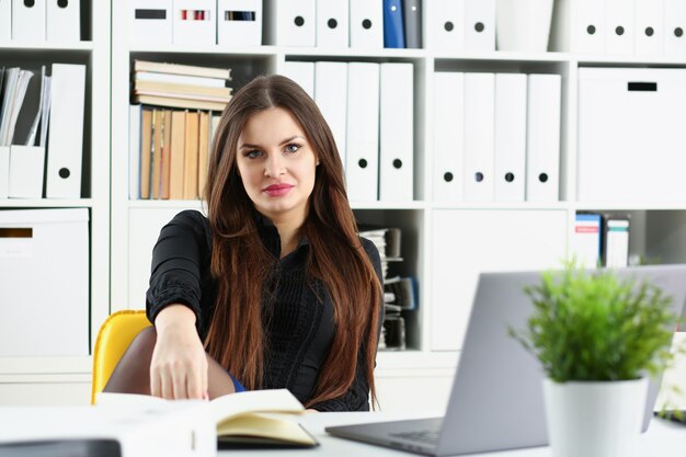 Hermosa chica de empleado sonriente en el lugar de trabajo hablar con el visitante